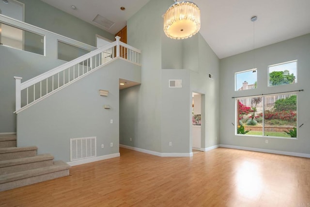513 Shadow Tree Dr, Oceanside, CA 92058 - unfurnished living room featuring a high ceiling, wood finished floors, stairway, and baseboards