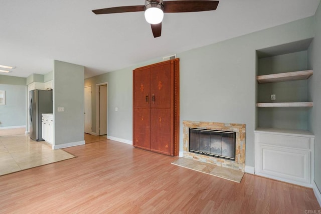 513 Shadow Tree Dr, Oceanside, CA 92058 - unfurnished living room with ceiling fan, light wood-style flooring, a fireplace, and baseboards
