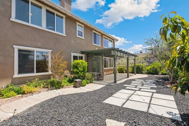 4224 Oliphant Ct, Riverside, CA 92505 - back of property with a pergola, a patio area, a chimney, and stucco siding