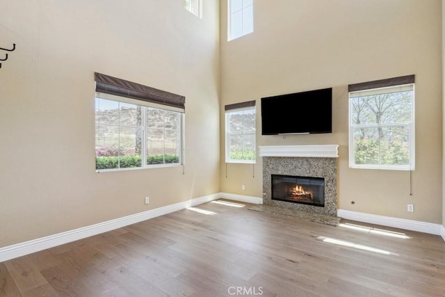 4224 Oliphant Ct, Riverside, CA 92505 - unfurnished living room with wood finished floors, baseboards, a premium fireplace, and a towering ceiling