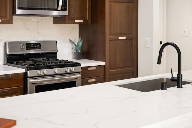 4158 Seri St, San Diego, CA 92117 - kitchen featuring appliances with stainless steel finishes, a sink, dark brown cabinetry, and decorative backsplash