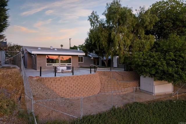 4158 Seri St, San Diego, CA 92117 - back of property at dusk with a patio, stucco siding, and a gate