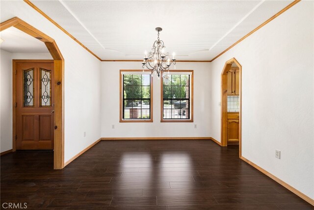 22635 Juanita Ct, Red Bluff, CA 96080 - unfurnished dining area featuring a chandelier, arched walkways, crown molding, dark wood-style flooring, and baseboards