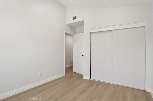 12548 Terra Bella St, Pacoima, CA 91331 - unfurnished bedroom featuring light wood-style flooring, baseboards, a closet, and high vaulted ceiling