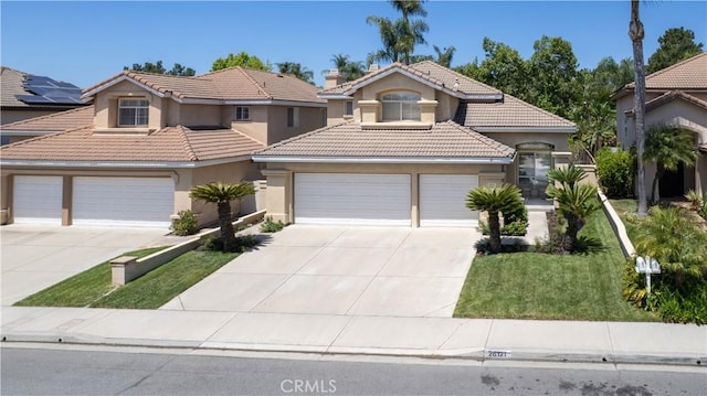 26121 Calle Cresta, Mission Viejo, CA 92692 - mediterranean / spanish house with driveway, stucco siding, a tiled roof, a front lawn, and an attached garage