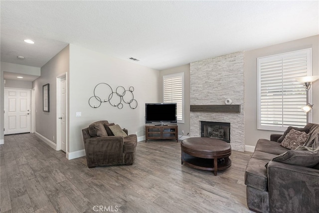 26121 Calle Cresta, Mission Viejo, CA 92692 - living area with wood finished floors, plenty of natural light, baseboards, and a stone fireplace