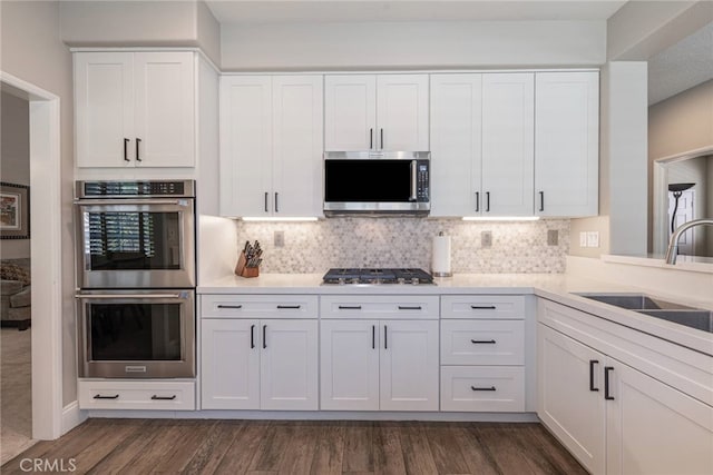 26121 Calle Cresta, Mission Viejo, CA 92692 - kitchen featuring appliances with stainless steel finishes, white cabinetry, a sink, and backsplash