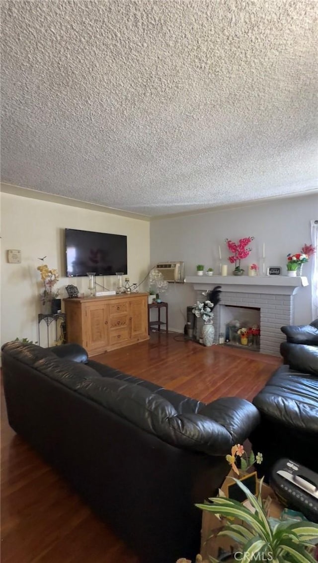 8758 S Hobart Blvd, Los Angeles, CA 90047 - living room featuring a textured ceiling, wood finished floors, an AC wall unit, and a fireplace