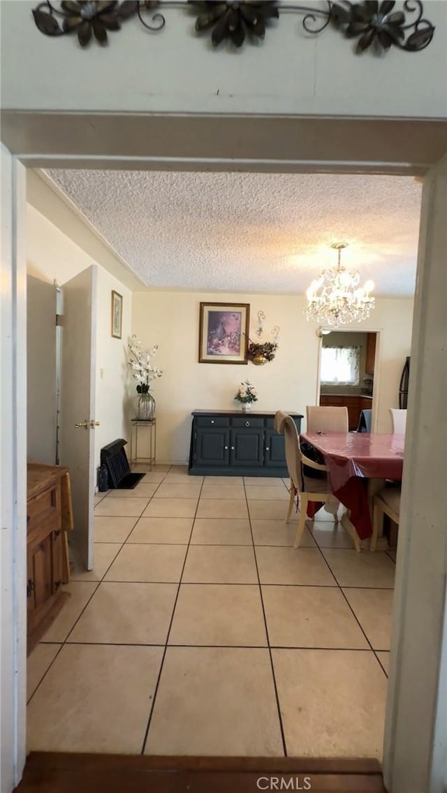 8758 S Hobart Blvd, Los Angeles, CA 90047 - dining area featuring light tile patterned flooring, a chandelier, and a textured ceiling