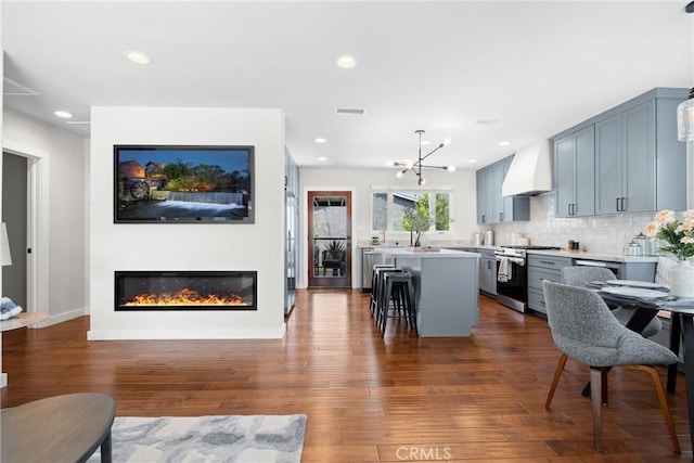 3409 W 175th St, Torrance, CA 90504 - kitchen with stainless steel gas range oven, premium range hood, a center island, dark wood-style flooring, and light countertops