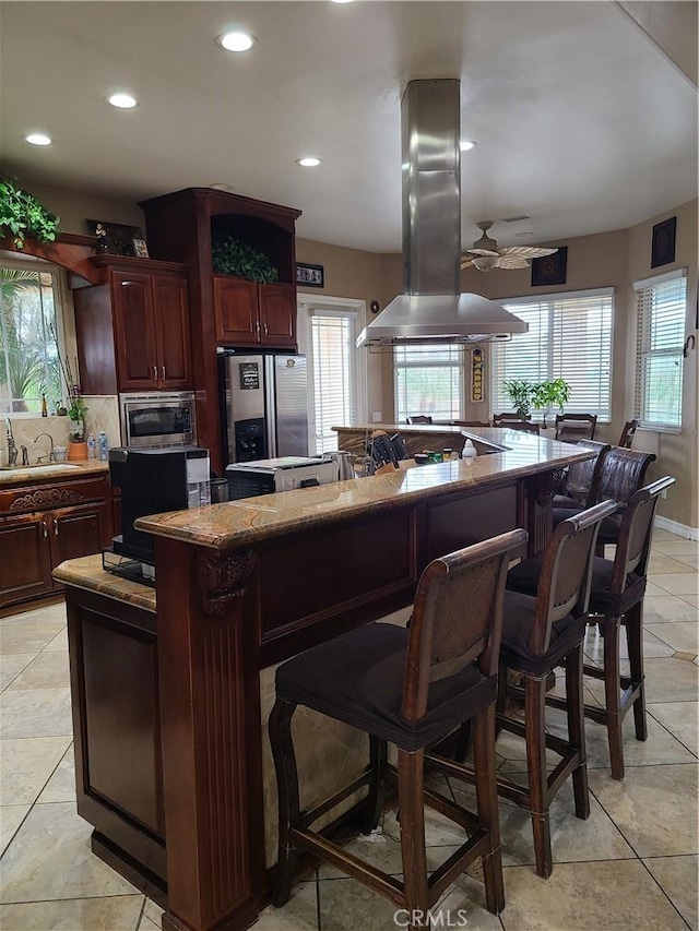 6116 Chadbourne Ave, Riverside, CA 92505 - kitchen featuring stainless steel appliances, island range hood, a center island, a sink, and a kitchen bar