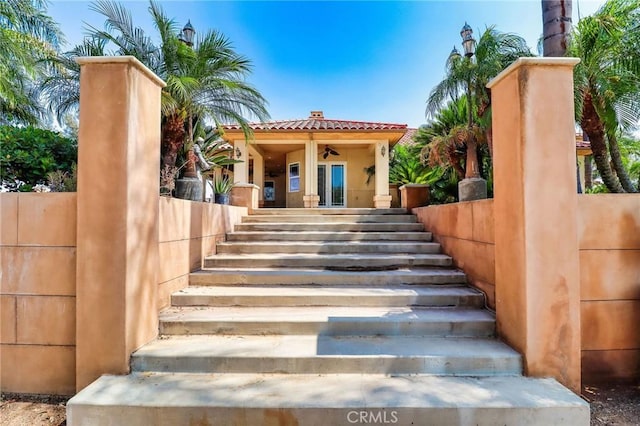 6116 Chadbourne Ave, Riverside, CA 92505 - view of exterior entry with a tiled roof, stucco siding, covered porch, and ceiling fan