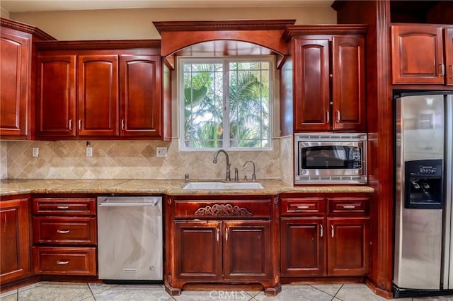 6116 Chadbourne Ave, Riverside, CA 92505 - kitchen featuring appliances with stainless steel finishes, dark brown cabinets, light stone countertops, and backsplash