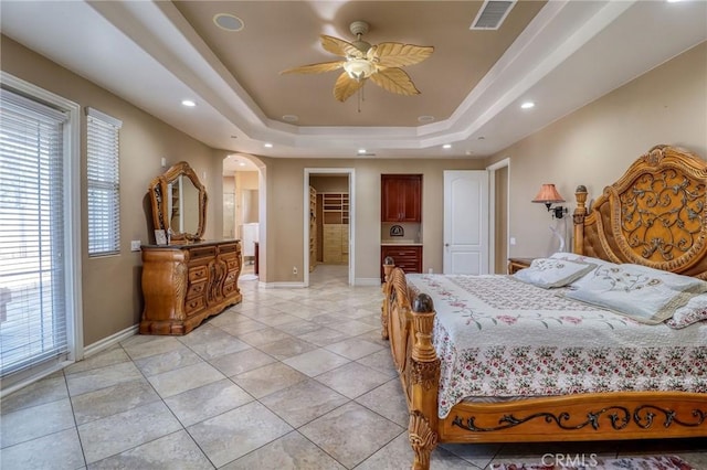 6116 Chadbourne Ave, Riverside, CA 92505 - bedroom featuring arched walkways, a tray ceiling, a walk in closet, light tile patterned flooring, and recessed lighting