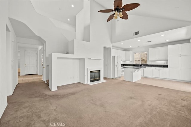 28538 Redwood Canyon Pl, Saugus, CA 91390 - unfurnished living room with light colored carpet, recessed lighting, a ceiling fan, high vaulted ceiling, and a sink