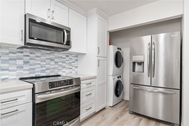 1310 E Ocean Blvd Unit 1103, Long Beach, CA 90802 - kitchen featuring stainless steel appliances, stacked washer / dryer, light countertops, decorative backsplash, and white cabinets