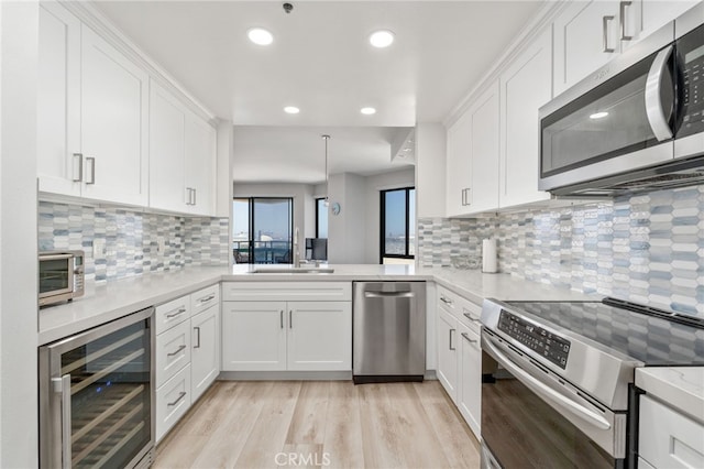 1310 E Ocean Blvd Unit 1103, Long Beach, CA 90802 - kitchen with stainless steel appliances, wine cooler, a sink, tasteful backsplash, and light countertops