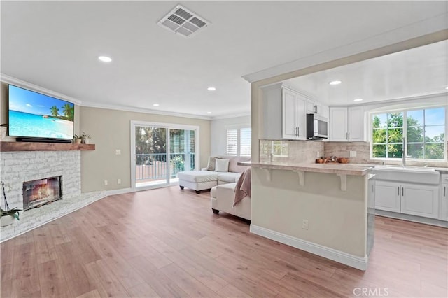 308 S Cabrillo Ave Unit 3, San Pedro, CA 90731 - kitchen featuring open floor plan, a breakfast bar area, light countertops, crown molding, and white cabinetry