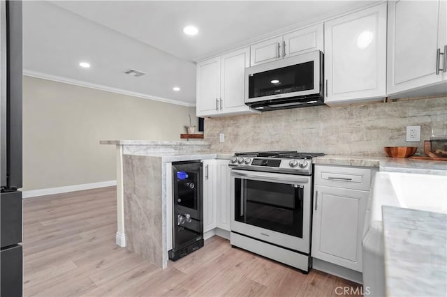 308 S Cabrillo Ave Unit 3, San Pedro, CA 90731 - kitchen featuring stainless steel range with gas cooktop, white microwave, wine cooler, ornamental molding, and light countertops