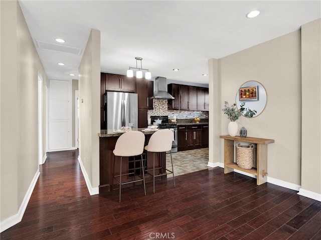 10404 Gaviota Ave, Granada Hills, CA 91344 - kitchen with appliances with stainless steel finishes, wall chimney range hood, a kitchen breakfast bar, dark brown cabinetry, and dark wood-style flooring