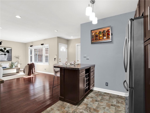 10404 Gaviota Ave, Granada Hills, CA 91344 - kitchen with freestanding refrigerator, dark brown cabinetry, a kitchen bar, hanging light fixtures, and recessed lighting