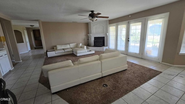 12780 Fir St, Oak Hills, CA 92344 - living room featuring light tile patterned flooring, a ceiling fan, a fireplace, baseboards, and french doors