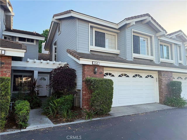 2342 Aspen St, Tustin, CA 92782 - view of front of property with an attached garage, brick siding, and asphalt driveway