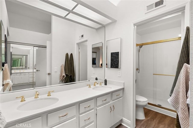 2342 Aspen St, Tustin, CA 92782 - bathroom featuring toilet, wood finished floors, a shower stall, and double vanity
