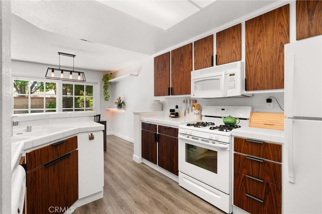 2342 Aspen St, Tustin, CA 92782 - kitchen with white appliances, light wood finished floors, tile counters, and a sink