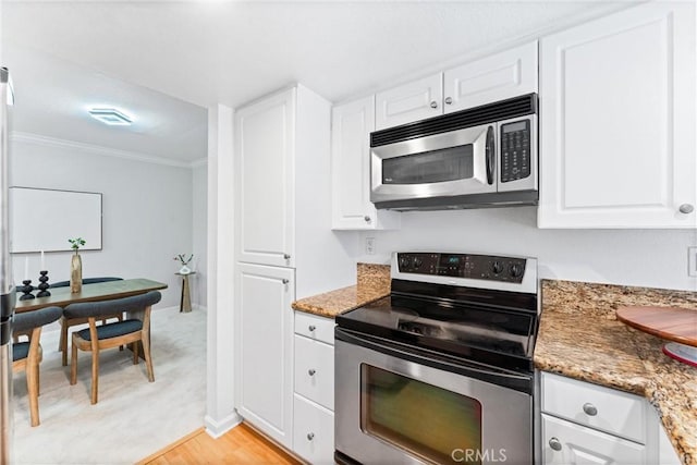 25541 Indian Hill Ln Unit P, Laguna Hills, CA 92653 - kitchen with appliances with stainless steel finishes, ornamental molding, white cabinets, light stone counters, and light wood finished floors