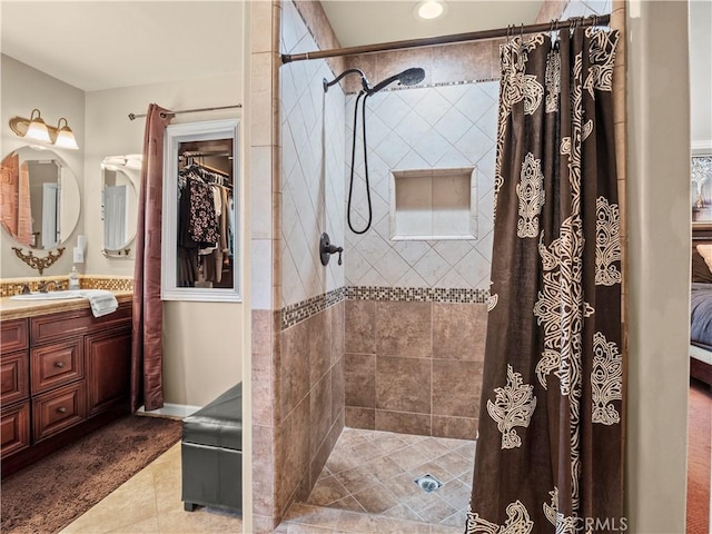 15242 Poppy Meadow St, Canyon Country, CA 91387 - bathroom featuring vanity, tile patterned floors, a tile shower, and a walk in closet