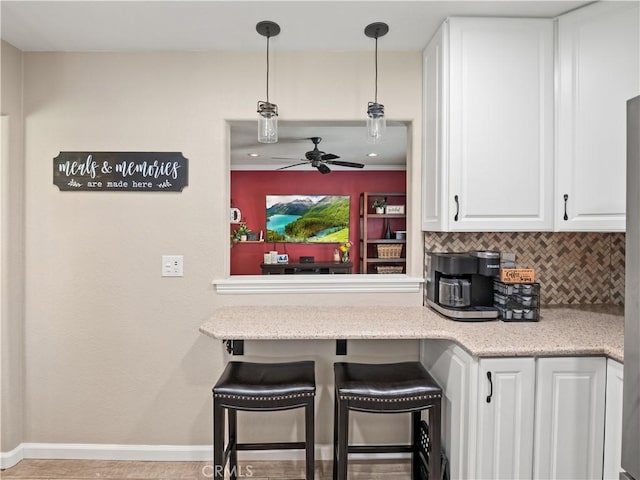 15242 Poppy Meadow St, Canyon Country, CA 91387 - kitchen featuring baseboards, white cabinetry, ceiling fan, tasteful backsplash, and decorative light fixtures
