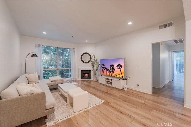 585 N Rossmore Ave Unit 209, Los Angeles, CA 90004 - living room featuring light wood-style flooring, plenty of natural light, a lit fireplace, recessed lighting, and baseboards