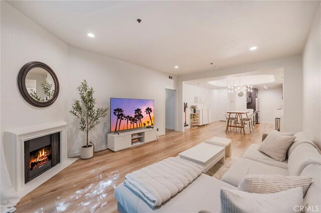 585 N Rossmore Ave Unit 209, Los Angeles, CA 90004 - living area featuring light wood-style floors, recessed lighting, a warm lit fireplace, a chandelier, and baseboards
