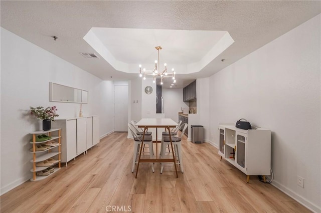 585 N Rossmore Ave Unit 209, Los Angeles, CA 90004 - dining room with light wood-style flooring, a chandelier, baseboards, a raised ceiling, and a textured ceiling