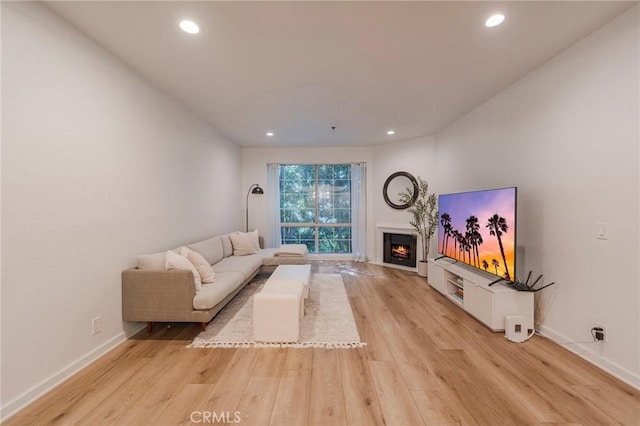 585 N Rossmore Ave Unit 209, Los Angeles, CA 90004 - living room featuring light wood-type flooring, a warm lit fireplace, recessed lighting, and baseboards