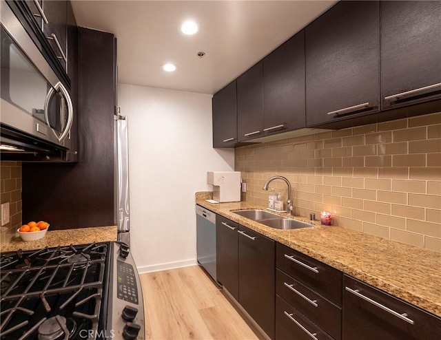 585 N Rossmore Ave Unit 209, Los Angeles, CA 90004 - kitchen with stainless steel appliances, a sink, decorative backsplash, light wood-type flooring, and recessed lighting
