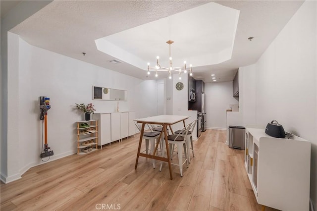 585 N Rossmore Ave Unit 209, Los Angeles, CA 90004 - dining space featuring a raised ceiling, light wood-style floors, baseboards, and a chandelier