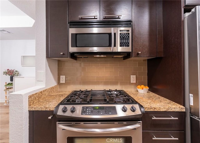 585 N Rossmore Ave Unit 209, Los Angeles, CA 90004 - kitchen featuring appliances with stainless steel finishes, dark brown cabinetry, decorative backsplash, and light stone counters