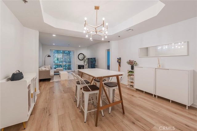585 N Rossmore Ave Unit 209, Los Angeles, CA 90004 - dining area with a raised ceiling, light wood-style flooring, a chandelier, recessed lighting, and a fireplace