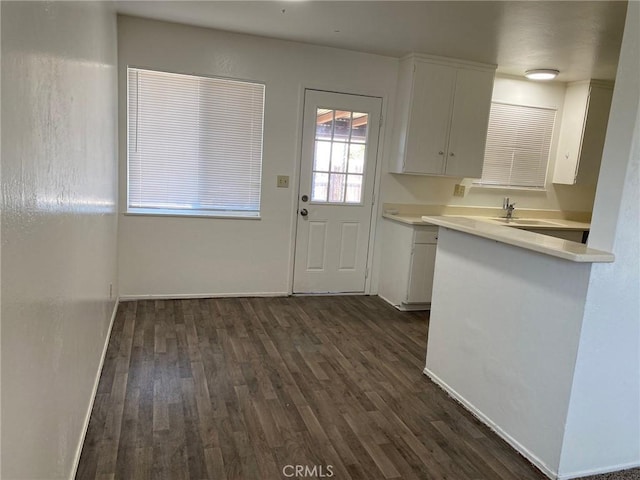 1017 W Prune Ave, Lompoc, CA 93436 - kitchen with dark wood-style floors, light countertops, white cabinets, a sink, and baseboards