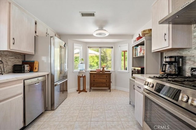 36364 Provence Dr, Murrieta, CA 92562 - kitchen with stainless steel appliances, wall chimney exhaust hood, tasteful backsplash, and light countertops
