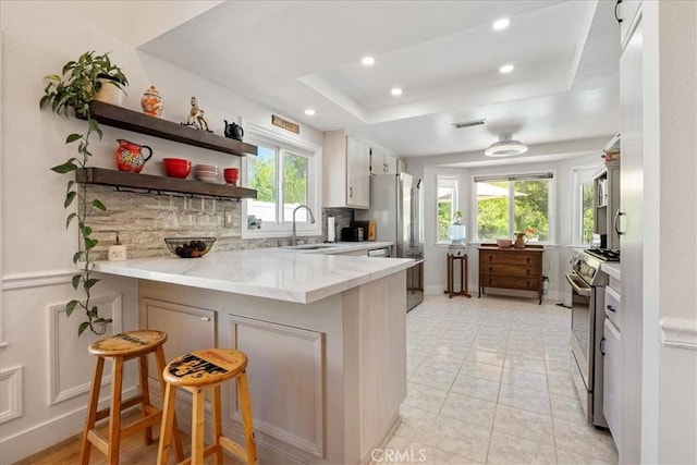 36364 Provence Dr, Murrieta, CA 92562 - kitchen with a sink, appliances with stainless steel finishes, a peninsula, recessed lighting, and a tray ceiling
