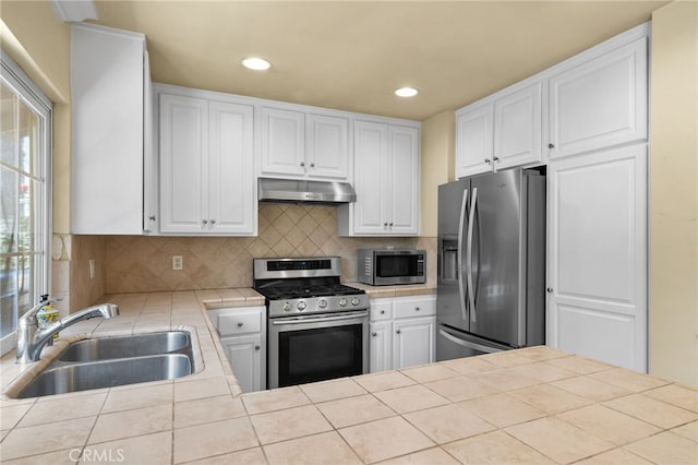 1725 Aspen Village Way, West Covina, CA 91791 - kitchen featuring appliances with stainless steel finishes, under cabinet range hood, a sink, tile counters, and white cabinetry