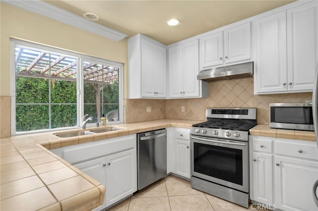 1725 Aspen Village Way, West Covina, CA 91791 - kitchen with appliances with stainless steel finishes, under cabinet range hood, a sink, tile counters, and white cabinetry