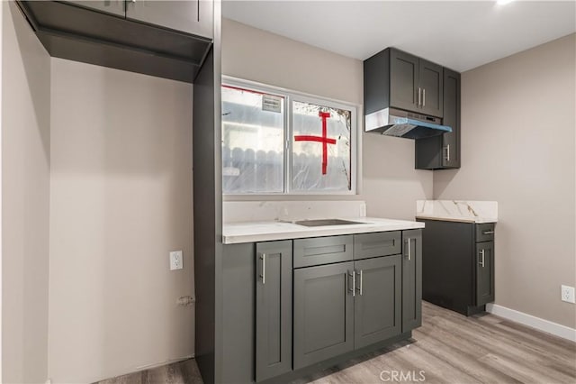 13250 Mercer St, Pacoima, CA 91331 - kitchen featuring light wood-type flooring, under cabinet range hood, gray cabinets, and light countertops
