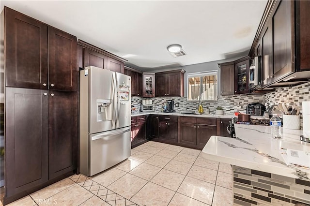 13250 Mercer St, Pacoima, CA 91331 - kitchen with appliances with stainless steel finishes, a sink, tasteful backsplash, dark brown cabinetry, and glass insert cabinets