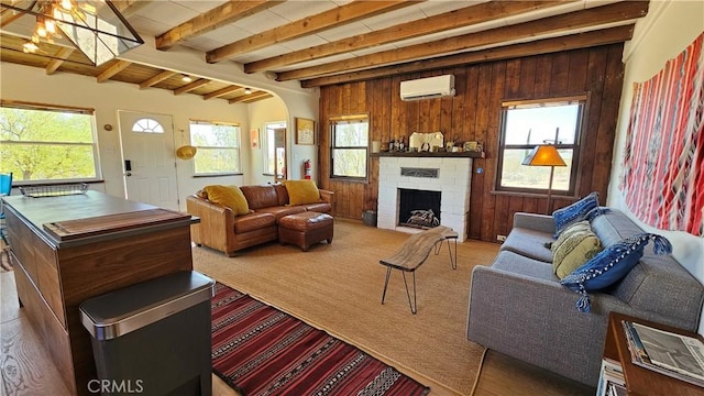 1240 Geronimo Trl, Yucca Valley, CA 92284 - carpeted living area featuring a wall mounted air conditioner, healthy amount of natural light, arched walkways, wooden walls, and a fireplace