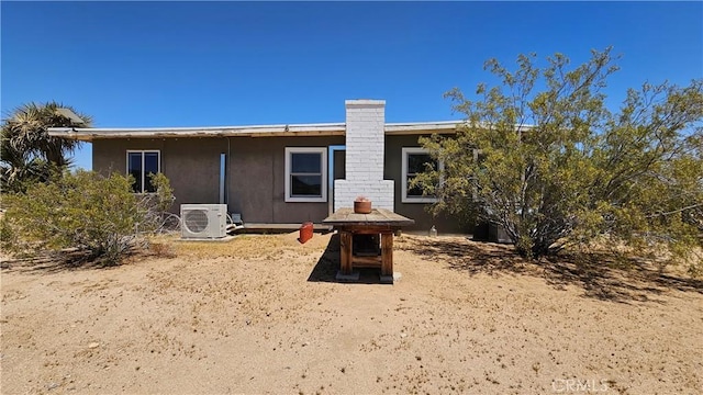 1240 Geronimo Trl, Yucca Valley, CA 92284 - rear view of property featuring a cooling unit and a chimney