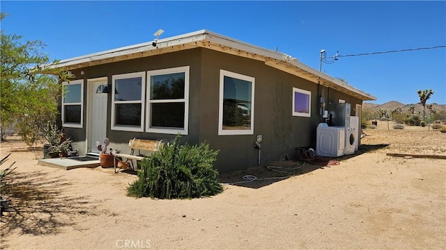 1240 Geronimo Trl, Yucca Valley, CA 92284 - view of home's exterior with separate washer and dryer and a cooling unit